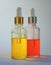 Two glass clear bottles with pipettes and bright Golden and red