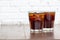 Two glass cool ice cola carbonated soft drink liquid fresh food with soda water on wooden table in restaurant, Close up