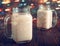 Two glass cups of hot cocoa with milk and sugar, on wooden table