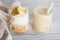 Two glass cups with ingredients banana, honey, oatmeal and yogurt and smoothie