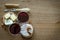 Two glass of red wine with few pieces of cheese and knifes at wooden background. top view