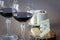 Two glass of red wine with few pieces of cheese at wooden background. close-up