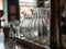 Two glass water pitchers with condensation sitting on bar counter