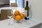 Two glasses, a bottle of white wine and a bowl of oranges close-up