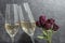 Two glasses with champagne with a bunch of flower with dried red roses