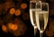 Two glasses of champagne with golden bokeh