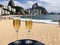 Two Glasses Of Champagne On A Table On The Beach. Generative AI