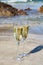 Two glasses of champain or cava sparkling wine served on the white sandy tropical beach, luxury resort with sea view, romantic va