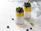 Two Glasses of chia pudding with blueberries, mango mousse and oat granola on the kitchen table