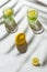 Two glasses of cocktail or water with sliced lemon and mint on white sunlit background with palm tree leaf shadow. Summer