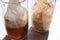 Two glasses of cola with ice cubes on white table. Top view, copy space. Hard light, shadow.  Refreshing summer drink