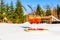 Two glasses of cold Aperol Spritz on tray of snow on sunny frosty day in winter, pines and fir trees on background. Restaurant or