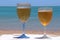 Two glasses of cold beer by sea. Chilled beer in glasses on table on seacoast