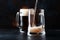 Two glasses of german light beer, beer poured into mug, dark bar counter background, selective focus