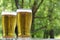 Two glasses of golden cold beer on wooden table, outdoor. With copy space, close up.