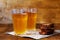 Two glasses of homemade bread kvass with black rye bread and hard chucks on a wooden table