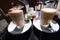 Two glasses of latte macchiato with macaron french dessert