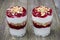 Two glasses with layered dessert with yogurt, cherries, granola