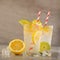 Two glasses of lemonade with lemons and lime and straw, a cool drink and summer mood, with ice