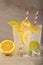 Two glasses of lemonade with lemons and lime and straw, a cool drink and summer mood, with ice