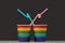 Two glasses of LGBT color with pink and blue cocktail tubes. Gray background. The concept of unification and love of people of a