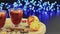 Two glasses of mulled wine on a rotating wooden tray with glowing lights