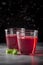 Two glasses with pink drink of berries, juice, jelly. Dark background