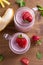 Two glasses of pink strawberry milkshake or cocktail. Strawberry banana smoothie on wooden table.