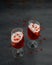 Two glasses with red gelatin, wiiped cream and pomegranate seeds on the top