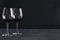 Two glasses of red thick and heavy, mouthfeel wine on the rustic surface agaisnt black background