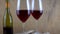 Two glasses of red wine. Alcoholic drink in a glass. A bottle of wine. Wooden background.