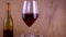 Two glasses of red wine. Alcoholic drink in a glass. A bottle of wine. Wooden background.