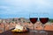 Two glasses of red wine with charcuterie assortment on view of Dubrovnik red roofs. Glass of red wine with different snacks -