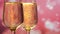 Two glasses with sparkling champagne over pink with hearts background. Close up