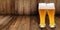 Two glasses of wheat beer making cheers on a wooden background