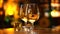Two glasses of white wine in a candle lit restaurant wine cellar. Glass of green wine standing on a table in a barrel storage,