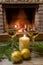 Two glasses of white wine, candle, yellow glass balls, near cozy firepace