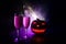 Two glasses of wine and bottle with Halloween - old jack-o-lantern on dark toned foggy background. Scary Halloween pumpkin. Useful