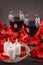 two glasses of wine, candles and red roses on a black background