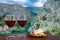 Two glasses of wine with cheese and meat snacks with view of Cetina River, mountains and old town Omis, Croatia. Cetina river