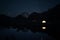 Two glowing tents in high mountains at night under starry sky