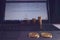 Two gold bitcoins are on a laptop. Several rows of coins are in the background. An internet page with graphs of changes in the