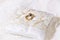 Two gold shiny wedding rings together on satin lace pillow