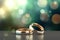 Two gold wedding rings are in front of a bokeh background, in the style of digitally enhanced, light green