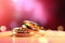 Two gold wedding rings are in front of a pink bokeh background, in the style of digitally enhanced,