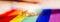 Two gold wedding rings on rainbow lgbt flag. Homosexual marriage