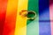 Two gold wedding rings on rainbow lgbt flag. Homosexual marriage