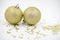 Two golden christmas balls baubles on a white background with blurry golden stars