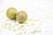 Two golden christmas balls baubles on a white background with blurry golden stars