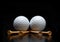 Two golf balls with tees laying on a black reflective surface. Low angle with copy space